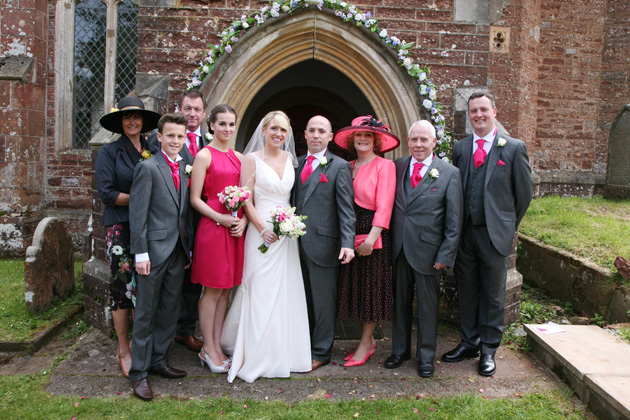 The bride and groom and families pose for a photo outside the wedding venue | Confetti.co.uk