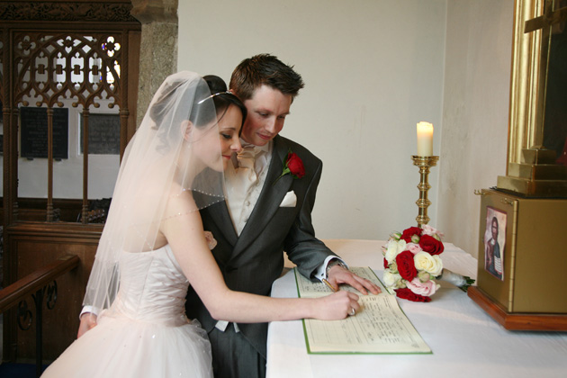 Newlyweds signing the register | Confetti.co.uk