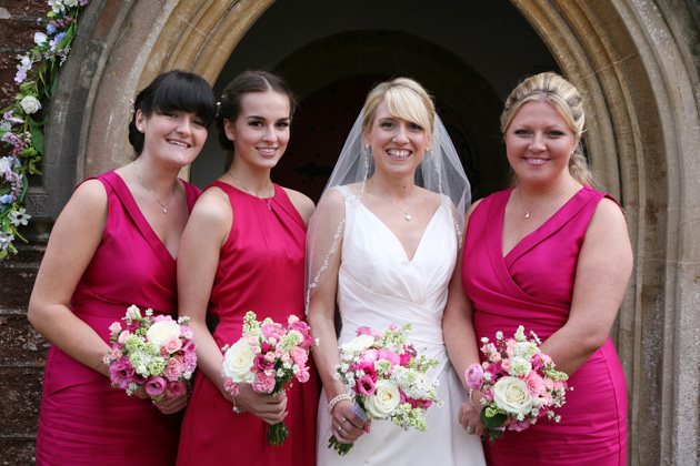 The bride in her blush pink wedding dress and bridesmaids in their hot pink sleeveless dresses | Confetti.co.uk