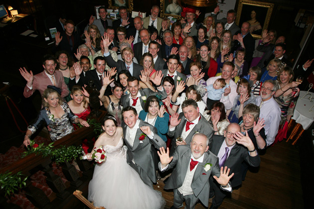 Group shot of the bride and groom with wedding guests | Confetti.co.uk