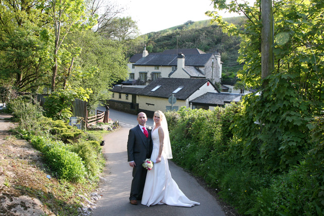 The bride and groom pose in a quaint English village on their wedding day | Ava Images | Confetti.co.uk