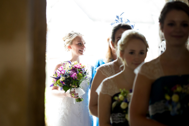 Bride and the bridesmaids walking in to the church | Confetti.co.uk