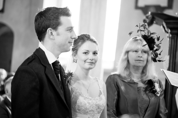 Black and white image of the bride and groom at the alter | Confetti.co.uk