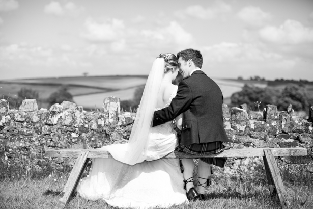 Bride and groom sitting on the bench | Confetti.co.uk