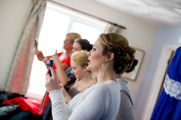 Bridesmaids taking a picture of the bride | Confetti.co.uk