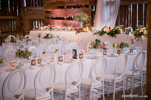 Banqueting wedding tables with white chairs, white linen with Rustic centrepieces  Confetti.co.uk   