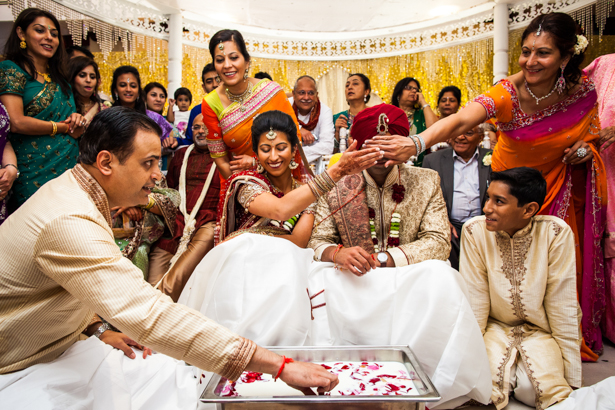 Bride and groom playing a traditional game of hiding their rings | Traditional Hindu wedding customs | Confetti.co.uk