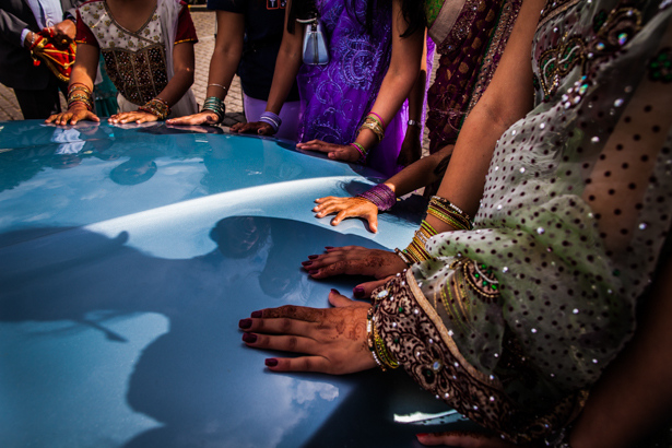 Wedding guests placing their hands on the wedding car | Traditional Hindu wedding | Confetti.co.uk