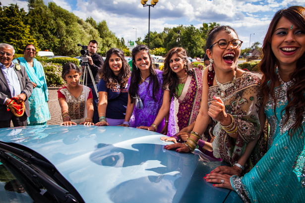 Wedding guests placing their hands on the wedding car | Traditional Hindu wedding | Confetti.co.uk