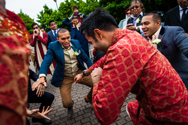 Wedding guests, in traditional Indian wedding outfits, dancing as they make their way to the Hindu wedding ceremony | Confetti.co.uk