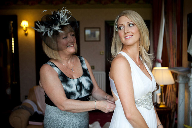 Mother of the Bride Wedding Duties | Mother of the bride helping the bride with her wedding dress | Touching moments with the bride and her mum | Confetti.co.uk