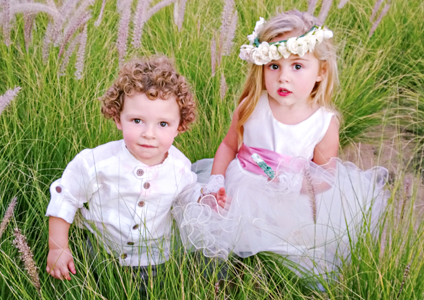 Adorable page boy and flower girl in the grass | Confetti.co.uk