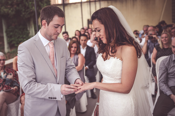 Groom placing the ring on the brides finger | Morgan and James Real Wedding By Infinity Weddings | Confetti.co.uk