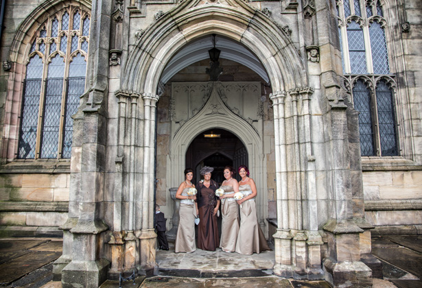 Bridesmaids in long brown strapless dress outside the St. Michael and all Angels’ church in Ashton | Becki and Rob’s Real Wedding By Jenny Martin Photography | Confetti.co.uk