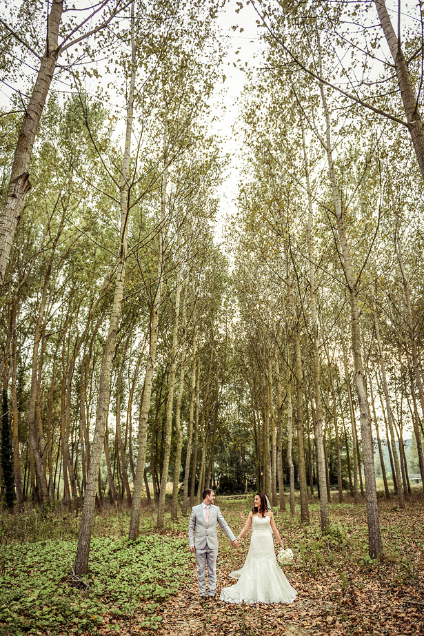 Official wedding shot in the forest | Bride and groom holding hands in the forest | Morgan and James Real Wedding By Infinity Weddings | Confetti.co.uk