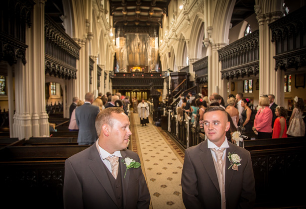 Groom and the best man waiting at the altar in the St. Michael and all Angels’ church in Ashton | Becki and Rob’s Real Wedding By Jenny Martin Photography | Confetti.co.uk