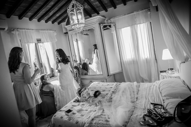 Bridesmaids helping the bride get ready for her big day | White and silver bridal shoes| Morgan and James Real Wedding By Infinity Weddings | Confetti.co.uk