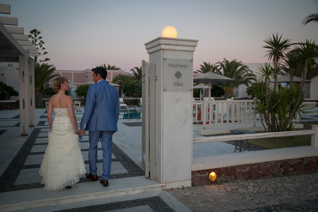 The bride and groom walking in to the Pantheon villas Santorini for their wedding reception | Wedding portfolio by Creative Shotz | Dasha and Steve's Real Wedding In Greece | Marryme in Greece | Confetti.co.uk