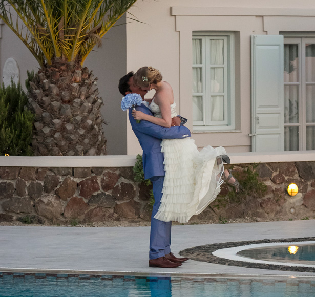 Bride and groom kissing by the pool side at the Pantheon villas Santorini| Wedding portfolio by Creative Shotz | Dasha and Steve's Real Wedding In Greece | Marryme in Greece | Confetti.co.uk