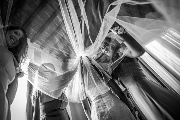 Long bridal veil | Bridesmaids helping bride with her veil | Morgan and James Real Wedding By Infinity Weddings | Confetti.co.uk