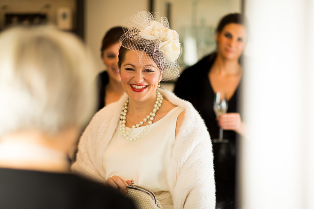 Bride ready for her big day | Bride in her white fur shawl, pearls and white vintage inspired dress  | Abigail and Chris's Real Christmas Wedding | Confetti.co.uk 