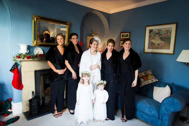 Bride in her vintage inspired white dress with her bridesmaids in black sleeveless dress  | Abigail and Chris's Real Christmas Wedding | Confetti.co.uk 