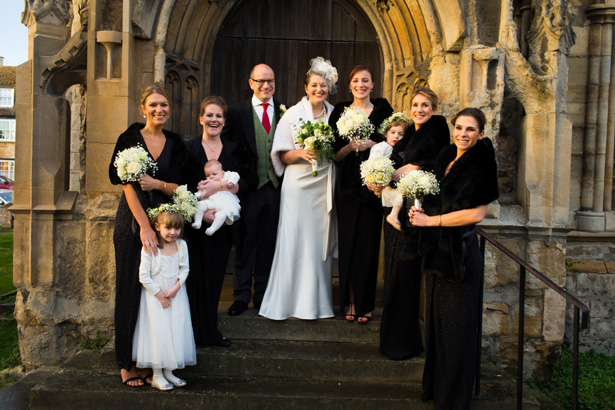 The newlyweds and bridesmaids outside the church | Abigail and Chris's Real Christmas Wedding | Confetti.co.uk 