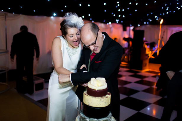 Bride and groom cutting their cheese wedding cake| Abigail and Chris's Real Christmas Wedding | Confetti.co.uk 