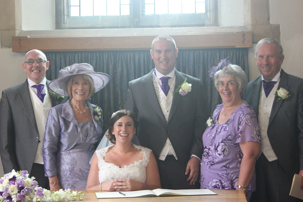 Nearly weds signing the register with their family| Purple themed wedding| Rhiannon & Michael's Real Wedding | Confetti.co.uk