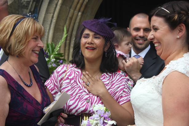 Bride having a laugh with her wedding guests | Purple themed wedding| Rhiannon & Michael's Real Wedding | Confetti.co.uk