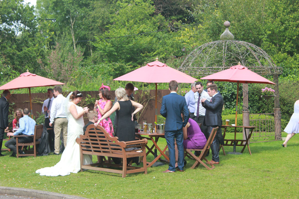 Bride with her wedding guests in the gardens of De Courcey’s Manor, Cardiff| Purple themed wedding| Rhiannon & Michael's Real Wedding | Confetti.co.uk