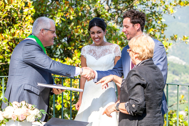 The newlyweds shaking the hands of the registrar |  Outside wedding ceremony ideas | Leanne and Chris's Real Italian Wedding | Confetti.co.uk