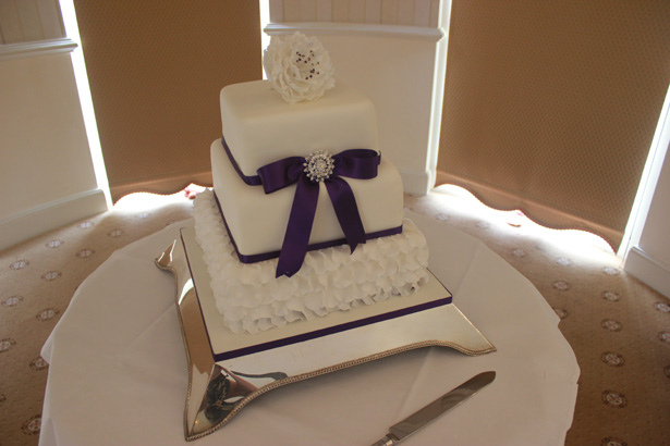 White and purple 3 tiered wedding cake| Purple themed wedding| Rhiannon & Michael's Real Wedding | Confetti.co.uk