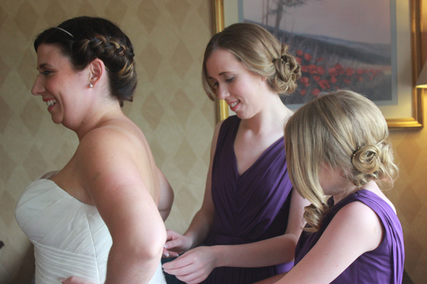 Bridesmaids helping the bride get ready | Purple themed wedding| Rhiannon & Michael's Real Wedding | Confetti.co.uk