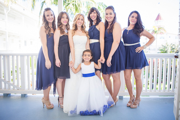 The bride in her strapless lace wedding dress with her bridesmaids in royal blue chiffon short dress and the flower girl in a white and blue dress | Crystal & Giampaolo California Real Wedding |Destination Wedding America | Confetti.co.uk 