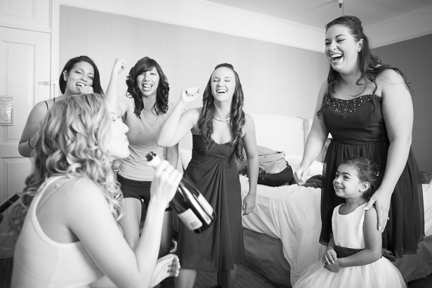 Bridesmaids cheering the bride on as she drinks champagne from the bottle as she gets ready | Crystal & Giampaolo California Real Wedding |Destination Wedding America | Confetti.co.uk 