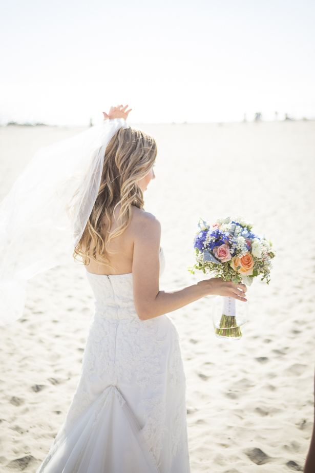 Bride walking on the beach with her bouquet in her hand | Crystal & Giampaolo California Real Wedding |Destination Wedding America | Confetti.co.uk 