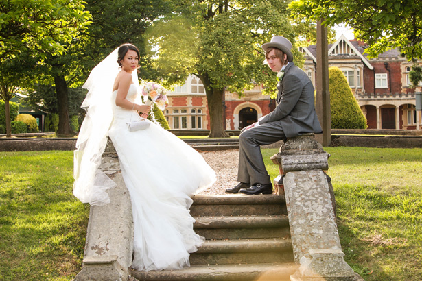  The bride and groom sitting on the stone staircase by Momentous Photography Ltd | Shasha and James real wedding | 1920’s Great Gatsby Wedding Confetti.co.uk 