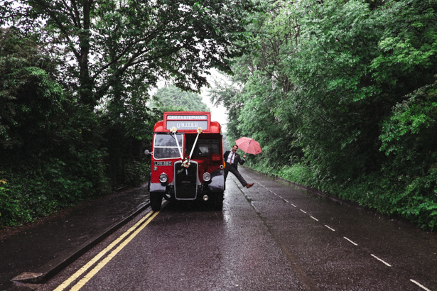 Guests heading to the reception on a vintage red London bus | Fun wedding ideas | Steph and Gary's Real Garden Wedding | Confetti.co.uk 