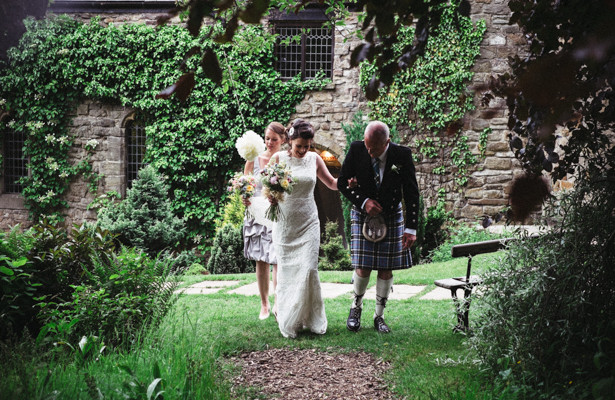 Bride making her way down to the garden ceremony with her father and bridesmaid | Steph and Gary's Real Garden Wedding | Confetti.co.uk 