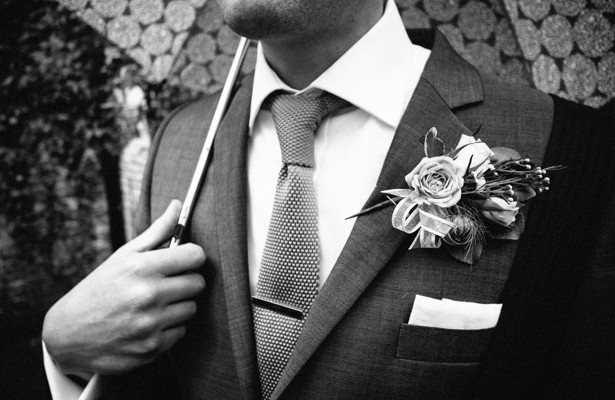 Vintage rose boutonniere  | Wedding guest holding an umbrella | Steph and Gary's Real Garden Wedding | Confetti.co.uk 