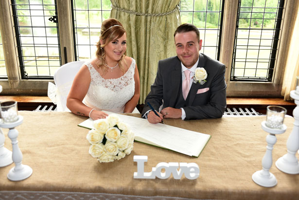 Laura and Daniel sign the registry; decor courtesy of Confetti.co.uk