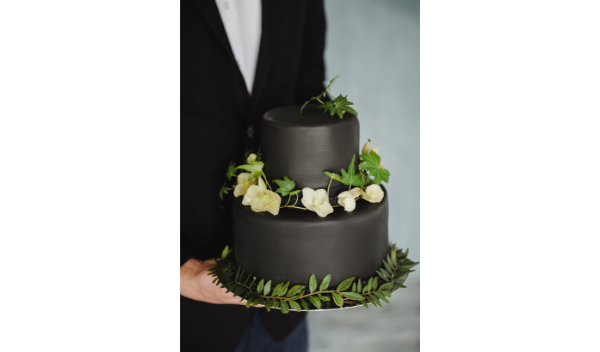 black wedding cake with white flowers and foliage