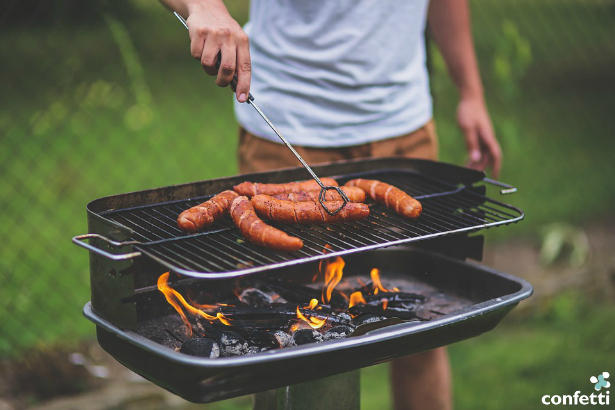 Man grilling sausages on a barbecue grill | Confetti.co.uk