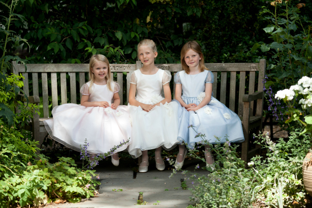 3 Junior bridesmaids sat on a bench | Confetti.co.uk