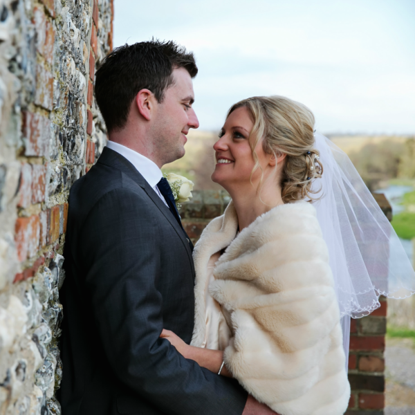 Bride and Groom Stare Lovingly Against an Exposed Brick Wall | Confetti.co.uk