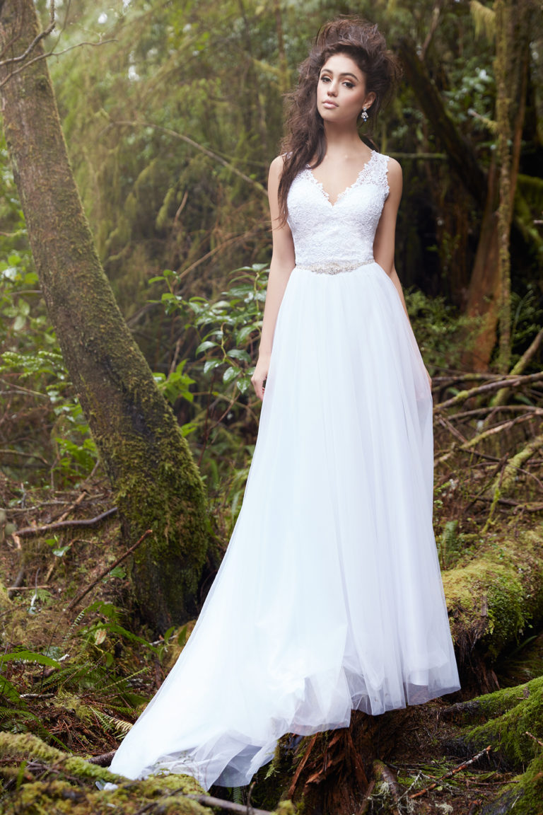 Beautiful bride posing in woodland backdrop in lace and tulle Allure Bridal dress