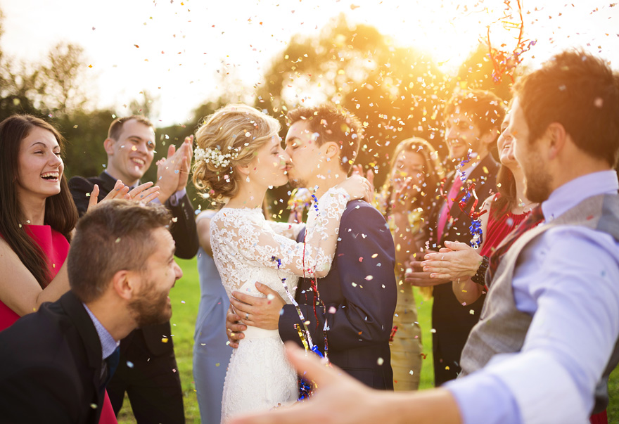 Kissing Bride and Groom in Confetti with Clapping Guests | Confetti.co.uk