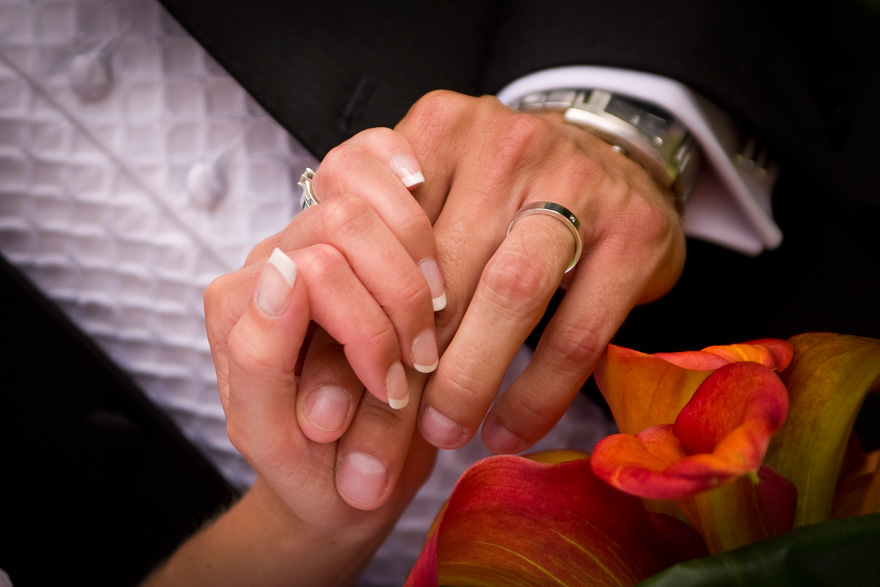 Bride and Groom Holding Hands Wearing Wedding Rings | Confetti.co.uk