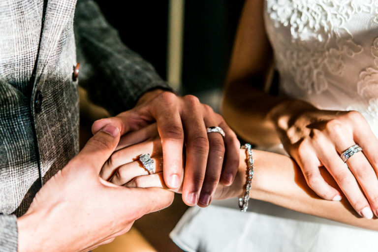 Bride and Groom Holding Hands and Showing Wedding Rings Photo Idea | Confetti.co.uk